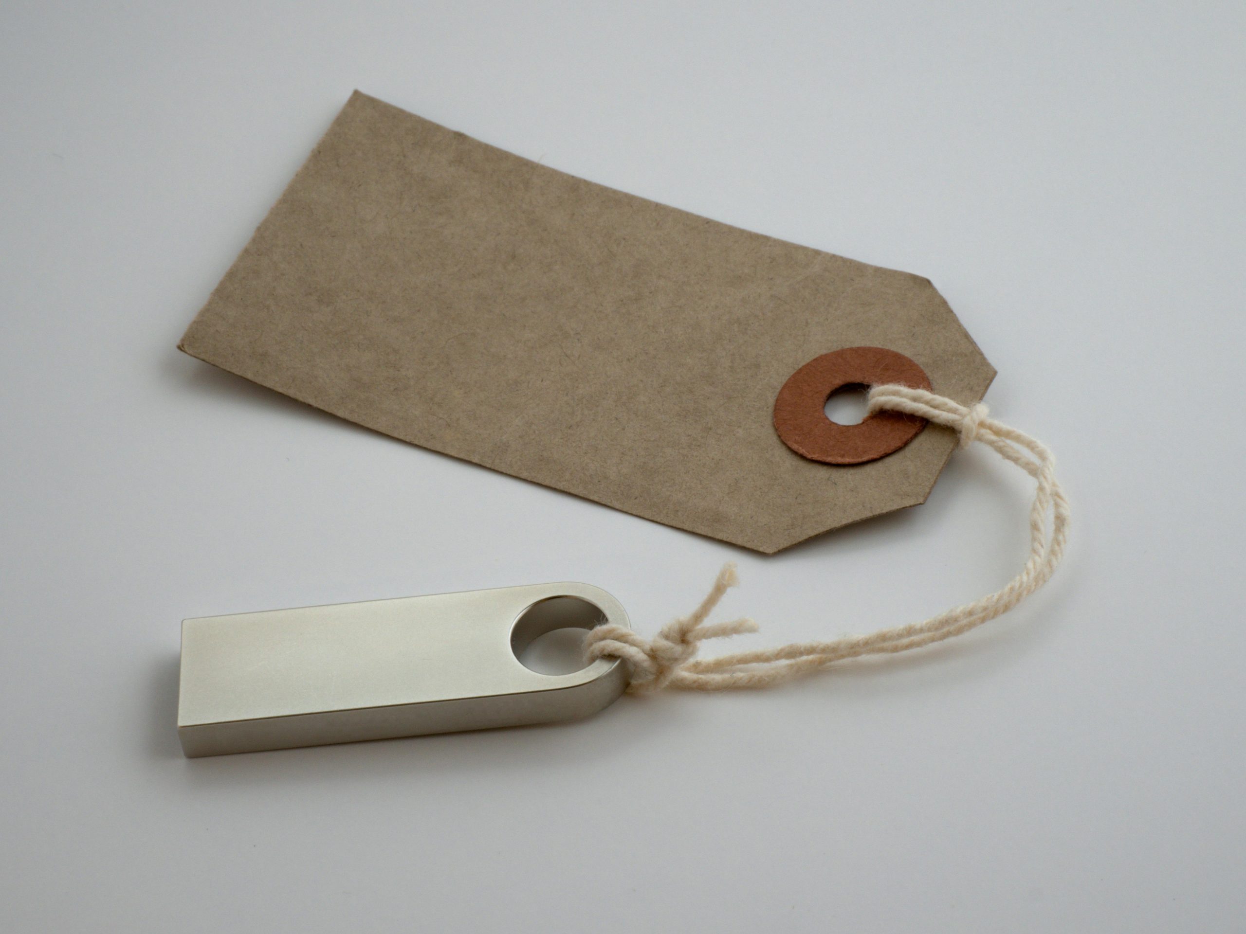 Je bent zoveel meer dan een label A minimalist paper tag with twine string on a neutral background, ideal for product labeling.